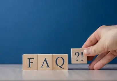 Holzwürfel bilden das Kürzel FAQ, eine Hand legt einen Würfel mit Fragezeichen dazu